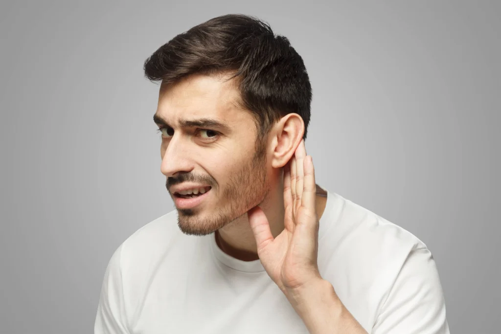 Homme qui tend l'oreille, en raison du bruit ambiant