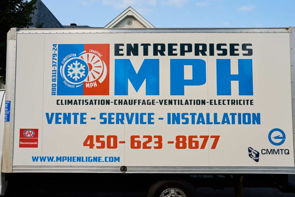 Photo d'un camion Entreprises MPH affichant les services en chauffage et climatisation, ainsi que le téléphone, 450-623-8677.