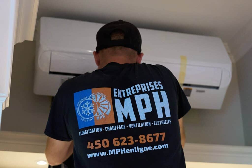 Technicien des Entreprises MPH en action, alors qu’il répare un climatiseur