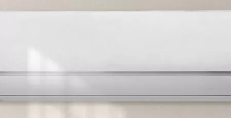 Thermopompe blanche au mur avec mains.