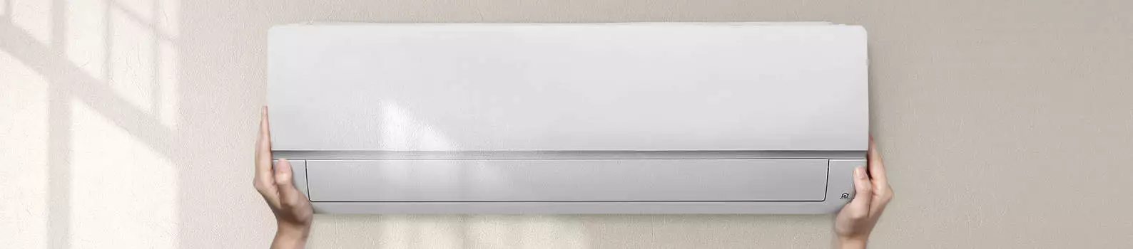 Thermopompe blanche au mur avec mains.