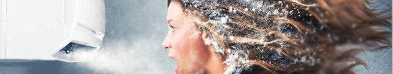 Une femme avec du givre dans les cheveux se tient devant un climatiseur mural trop puissant