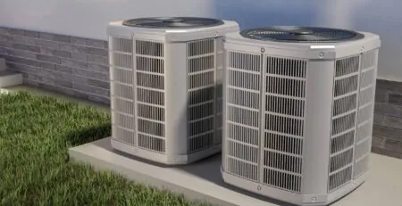 Deux unités extérieures de thermopompes résidentielles installées sur une dalle de béton