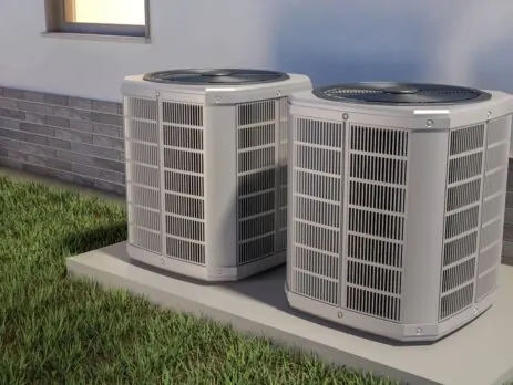 Deux unités extérieures de thermopompes résidentielles installées sur une dalle de béton