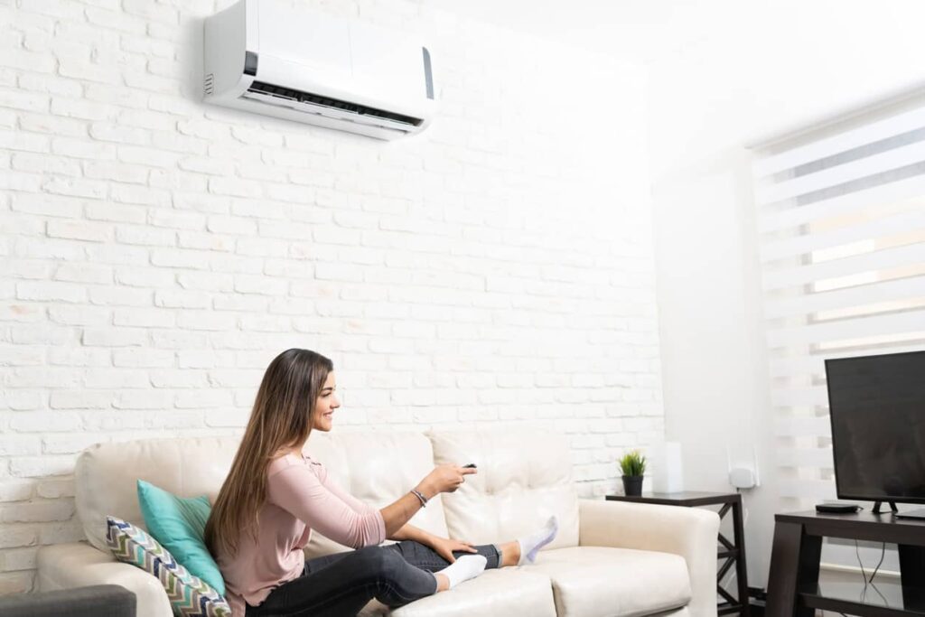 Femme utilisant son air climatisé dans son salon.