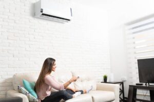 Femme utilisant son air climatisé dans son salon.