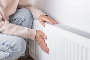 Femme posant les mains sur un radiateur pour se réchauffer