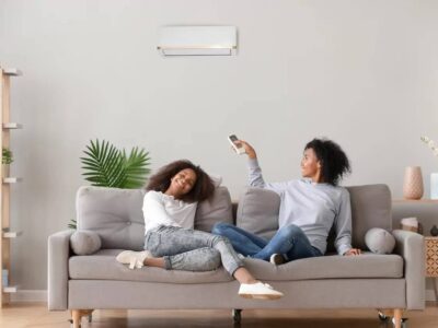 A mother and daughter relaxing on the sofa under the air conditioning of the heat pump.