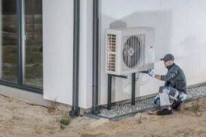 Expert installing the heat pump exterior unit.