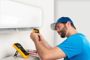 An expert is installing a wall-mounted heat pump.