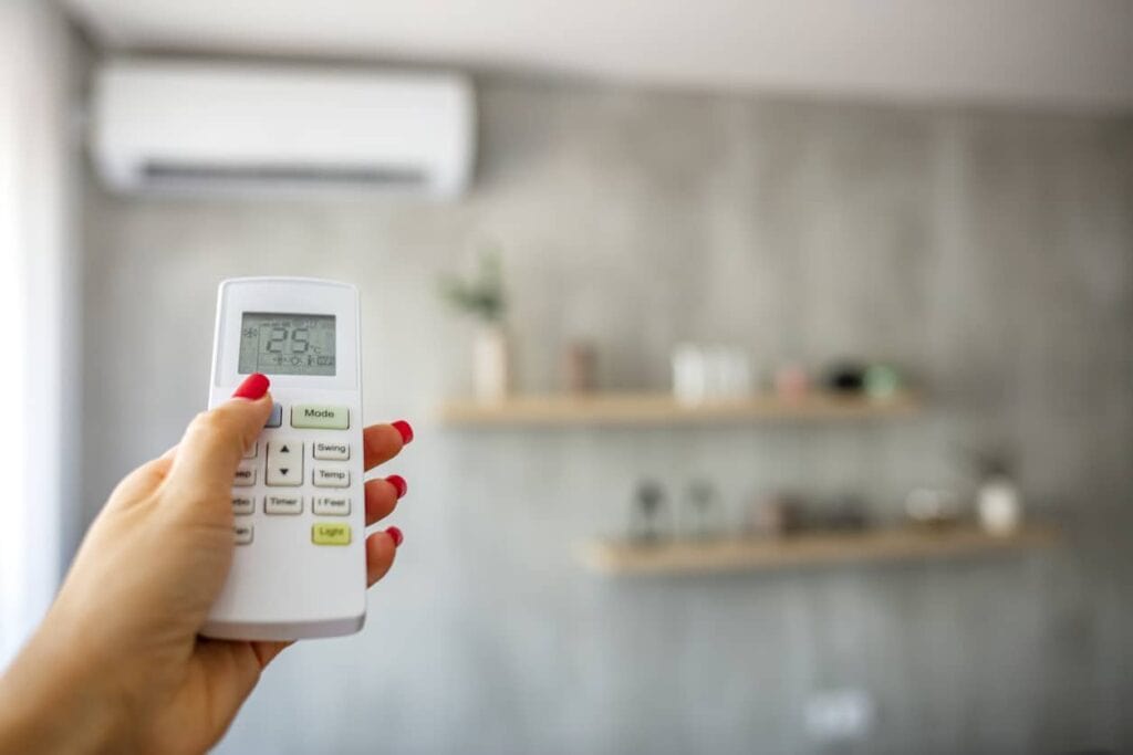Woman adjusting her heat pump settings with the remote control.