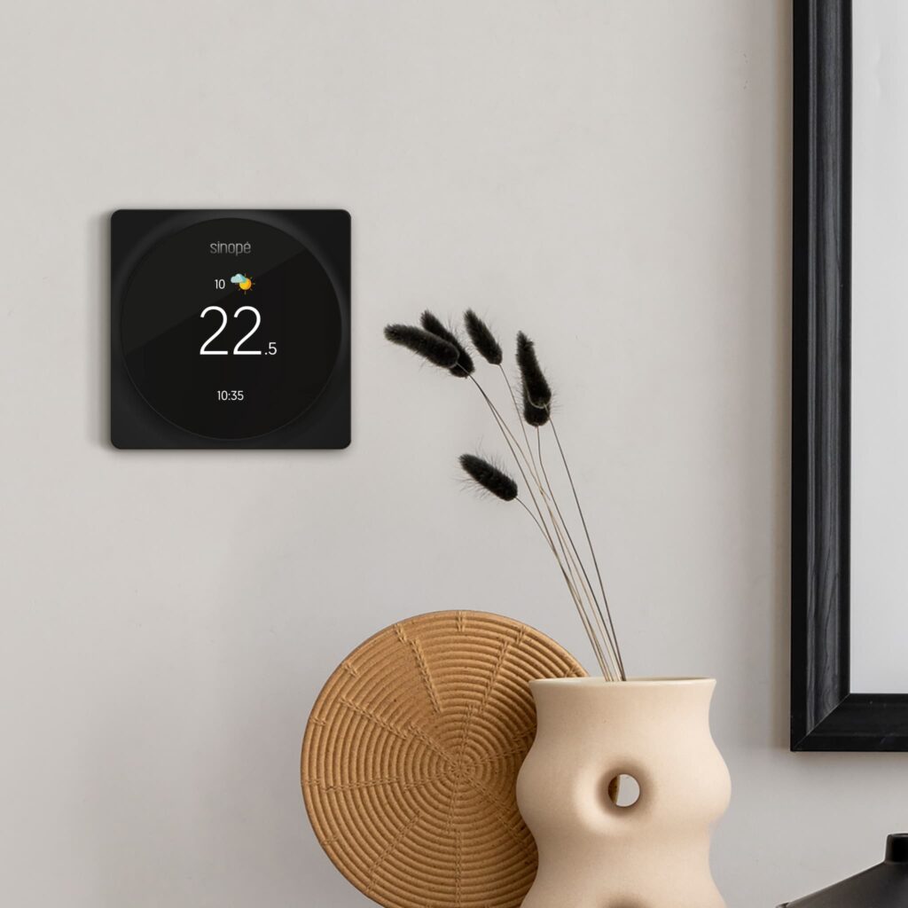 Le thermostat Sinopé TH6500WF installé au mur d’un salon